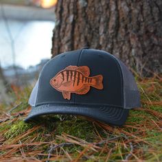 Custom Bluegill Leather Patch Hat. This trucker style hat is perfect to add your personalized touch to. Choose from our variety of hat color and leather color options. Fish patch engraved into our high quality leather patch hat. PRODUCT DETAILS -------------------------- ~ Richardson 112 trucker style snapback hats ~ Bluegill, sunfish, panfish on our high quality 100% genuine leather patch hats ~ Hat Color Options: Black, Navy, Heather Grey / Black, Charcoal / White, Navy / White, Charcoal / Bla Adjustable Trucker Hat For Fishing, Trucker Baseball Cap For Fishing, Curved Brim Trucker Hat For Fishing, Brown Curved Brim Trucker Hat For Fishing, Trucker Hat With Flat Bill For Fishing, Trucker Hat For Fishing With Flat Bill, Brown Fishing Cap, Brown Snapback Trucker Hat For Fishing, Brown Snapback Fishing Hat