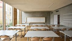 an empty classroom with desks and chairs in front of a whiteboard on the wall