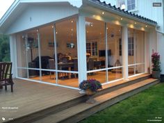 a house with glass walls and wooden decking