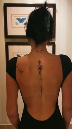 the back of a woman's body with tattoos on her upper and lower back