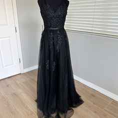 Black V-Neck Floral Lace Applique And Tulle Evening Dress New, With Tags. Never Worn, In Excellent Condition. No Holes Or Stains, No Fade. There Are A Couple Of Imperfect Areas On The First Layer Of Tulle (Circled In Photos),Which Are Not Noticeable When The Dress Is Worn (Due To The Black Lining). Size 6 Bust Is 34.5 Inches Waist Is 27.5 Inches Length Is Approximately 60" From Shoulder To Hem Measurements Are Approximate Sleeveless, Lined V-Neck In Front And Back Hidden Zipper Fabric & Lining: 100% Polyester Dry Clean Only Smoke Free Home! This Beautiful Dress Is Head-To-Toe Captivating With Floral Lace Over Three Layers Of Tulle On The Bottom. Lace V-neck Evening Dress For Party, V-neck Tulle Dress For Night Out, V-neck Tulle Dresses For Evening, V-neck Tulle Evening Dress, Lace V-neck Dress For Parties, Black V-neck Evening Dress For Night Out, Black V-neck Wedding Dress, Long Silver Dress, Black V-neck Dresses With Lace Trim