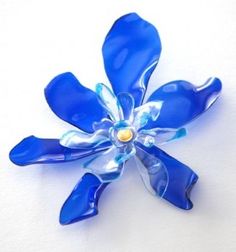 a blue flower brooch sitting on top of a white table