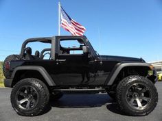 a black jeep with an american flag on top