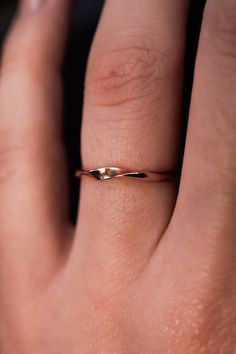 a woman's hand with a gold ring on her left thumb and the middle finger