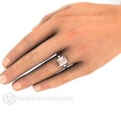 a woman's hand with a ring on it and a pink diamond in the middle