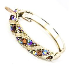 Lisner topaz and aurora borealis mid century signed vintage bangle bracelet. Good used condition with little to no signs of normal wear. No missing stone. Safety chain is still intact. Stamped on the inside of the band Lisner. Bracelet measures 6 and 3/4ths of an inch around and 3/8ths of an inch wide. Vintage Jeweled Bangle Cuff Bracelet, Vintage Jeweled Bangle For Wedding, Vintage Crystal Bangle Bracelet Gift, Costume Jewelry Crystal Bangle Bracelet, Vintage Jeweled Wedding Bangle, Vintage Jeweled Bangle Bracelet, Vintage Jeweled Bangle, Crystal Jeweled Bangle Bracelet For Formal Occasions, Vintage Jeweled Bracelets For Anniversary