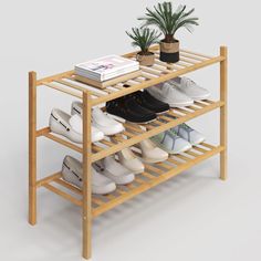 a wooden shoe rack with several pairs of shoes on it and a potted plant next to it