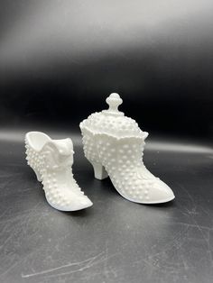 pair of white ceramic boots with beaded booties on the top and bottom, sitting next to each other