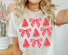 a woman wearing a t - shirt with watermelon bows on it