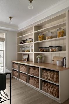 a kitchen filled with lots of shelves and wicker baskets