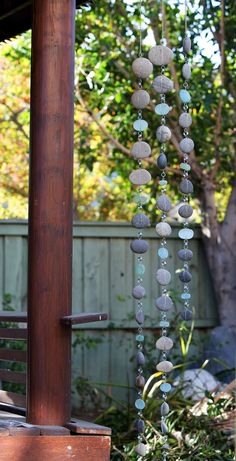 a wind chime hanging from the side of a wooden pole