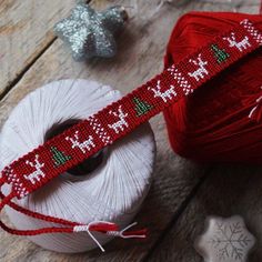 a spool of yarn next to two balls of thread and some ornaments on the table