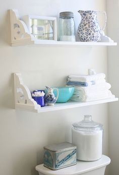 two shelves with dishes and cups on them, one is white the other is blue