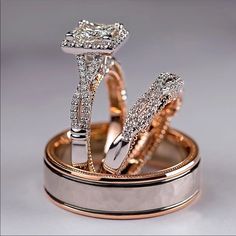 two wedding rings are sitting on top of each other in gold and silver with diamonds