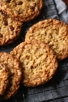 several oatmeal cookies sitting on top of a cooling rack with chocolate chips