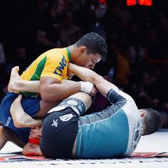 two men are wrestling in an arena