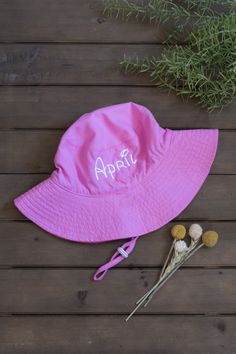 A super cute adjustable customized baby bucket hat for baby girl or toddler girl personalized with their first name! These baby sun hats are a vibrant bubble gum pink and baby name is custom embroidered using a sturdy, high-quality thread in white. The custom embroidery of the baby's first name gives your little one a one-of-a-kind style. A personalized baby bucket hat that keeps your baby girl protected from the sun all summer long and looking adorable! Hats are light-weight and the moisture wicking fabric makes them breathable which keeps baby comfortable during hot summer days! Embroidered beach hats for babies are the most darling summer accessory!  Buyer customizations are:  * choice of size (0-12 Months, Toddler) * choice of baby name up to 12 characters * choice of name font This li Cute Bucket Hat With Upf 50+ And Curved Brim, Adjustable Bucket Hat With Letter Print For Spring, Personalized Adjustable Brimmed Hats, Cute Brimmed Bucket Hat With Upf 50+, Cute Wide Brim Bucket Hat With Upf 50+, Cute Wide Brim Bucket Hat Upf 50+, Adjustable Letter Print Bucket Hat For Beach, Pink Curved Brim Hat For Playtime, Cute Pink Sun Hat For Outdoor