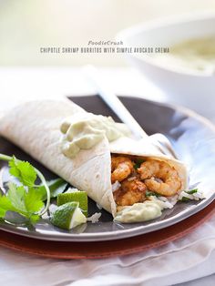 shrimp burrito with guacamole and cilantro sauce on a plate