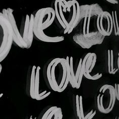 graffiti written on the side of a building in black and white, with words that spell out love