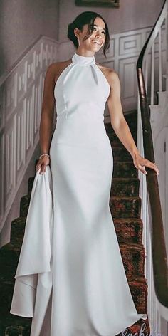 a woman in a white dress is standing on the stairs