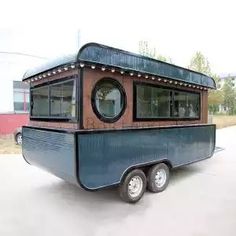 a small blue and brown trailer parked in a parking lot