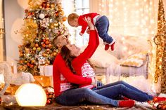 a man and woman are sitting on the floor with a baby in their arms while they look at each other