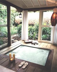 an outdoor hot tub with candles on the floor and some pictures above it that say, deblon - li - jeuxs ultimate relaxation, candles and a