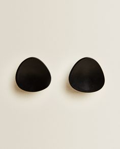 two black stones sitting side by side on a white surface