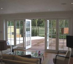 a living room with sliding glass doors leading to an outdoor deck and patio area in the background