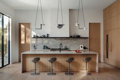 three stools sit in front of the kitchen island