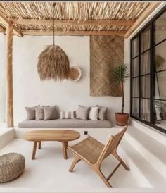 an outdoor living area with wicker furniture and potted plants on the side wall