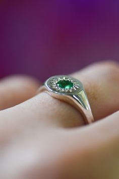 Express your distinct style with our meticulously crafted Daisy Signet Silver Ring. Highlighting a round-cut emerald, skilfully set in sterling silver, this piece seamlessly marries modern and traditional design elements. An embodiment of uniqueness, this exquisite emerald ring is an ideal choice for enhancing your everyday attire.Use the drop down menu to select your ring size and have the ring custom crafted just for you Details925 Sterling Silver jeweleryPersonalised jewellery handcrafted in Timeless Green Round Band Jewelry, Fine Jewelry With Polished Emerald Finish, Anniversary Jewelry With Polished Tsavorite, Timeless Polished Emerald Ring, Fine Jewelry Green Signet Ring With Birthstone, Emerald Signet Ring For May Birthstone, Timeless Green Sterling Silver Ring, Heirloom Style Green Emerald Ring With Polished Finish, Heirloom Style Polished Emerald Ring