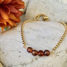 Elevate your style with this exquisite slider bracelet featuring lustrous golden stainless steel and stunning Natural Baltic Amber Beads in a warm cognac hue, each measuring 6mm. Handcrafted with precision and care, this bracelet combines timeless elegance with healing properties for a truly special accessory. Each bead is unique and there might be slight color difference or imperfections. 💎INTERESTING PROPERITIES OF YOUR STONES: Healing Benefits of Amber: Natural Baltic Amber is renowned for its therapeutic qualities. This ancient resin holds soothing energies that can help alleviate stress, anxiety, and promote emotional balance. Wearing Amber close to the skin can infuse your day with a sense of calm and well-being. 💎MATERIALS:   - Natural Baltic Amber Beads 6mm   - Gold Plated Stainl Slider Bracelet, Amber Bracelet, Bracelets Design, Amber Beads, Amber Stone, Amber Jewelry, Baltic Amber, Silver Accents, Healing Properties