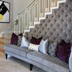 a grey couch sitting in front of a stair case