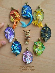 an assortment of miniature figurines sitting on top of a wooden table next to a person's hand