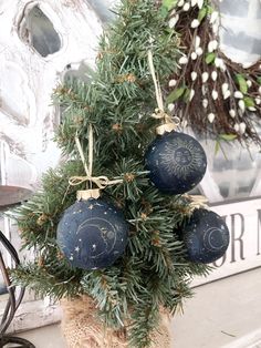 a potted plant with ornaments hanging from it's sides on a mantel