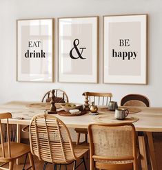 two framed art prints on the wall above a dining room table with chairs and place settings