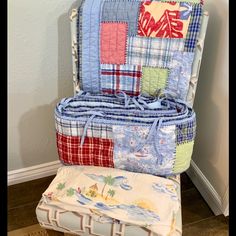 a chair made out of quilts and pillows on the floor next to a wall