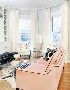 a living room filled with furniture and lots of windows