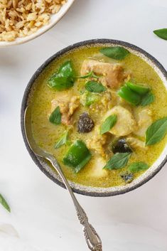 a bowl filled with green food next to rice