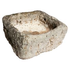 a stone bowl with dirt inside on a white background in the shape of a rectangle