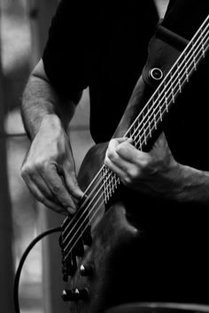 a man is playing an electric guitar in black and white