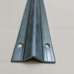 a metal strip with holes in it on a white tableclothed flooring area