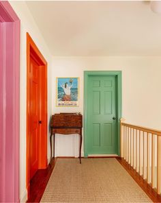 an entryway with two doors and a table in the middle, painted bright colors