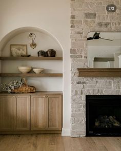 a living room filled with furniture and a fire place in front of a brick wall