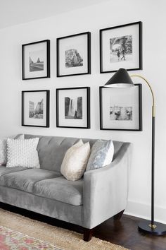 a living room with pictures on the wall and a couch in front of an area rug