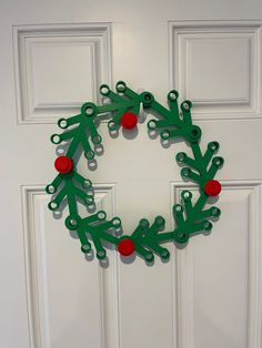 a christmas wreath made out of scissors on the front door