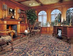 an ornate living room with wood paneling and large windowed windows overlooking the outdoors