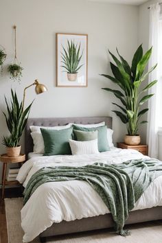 a bed with white sheets, pillows and green plants on the headboard in a bedroom