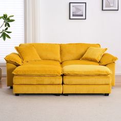 a yellow couch sitting next to a window in a living room